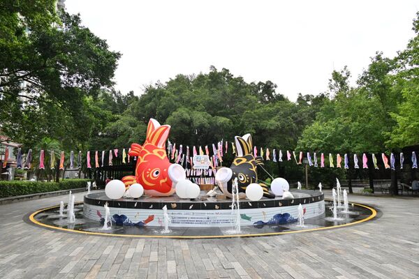 ▲「2026北投夏日祭り」即日起至6月21日登場，北投公園噴水池上方設有2隻鯉魚裝置，營造「鯉魚躍龍門」夜色。（圖／北市商業處提供）