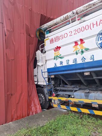 ▲載運飼料的大貨車疑煞車失靈，接連撞破磚牆和寺廟鐵皮屋，車內2人幸運輕傷。（圖／記者楊永盛翻攝）