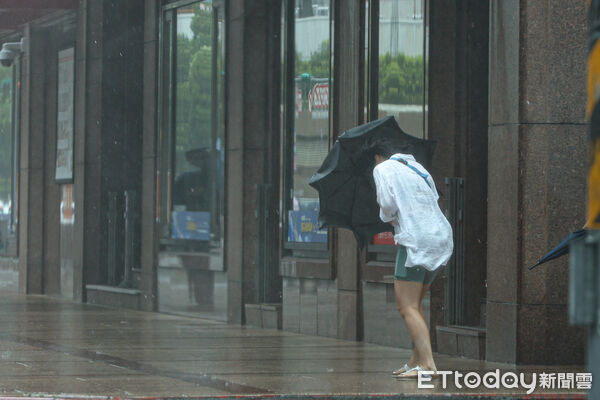 ▲巴威颱風挾帶強大風雨，北市民眾冒險出門。（圖／記者林敬旻攝）