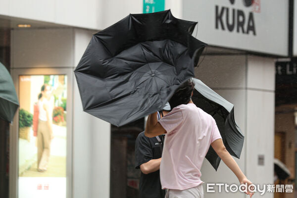 ▲巴威颱風挾帶強大風雨，北市民眾冒險出門。（圖／記者林敬旻攝）