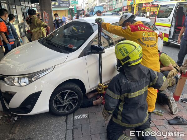 ▲台南安平老街附近12日下午發生車禍，1名50多歲男子遭自小客車壓住受困，消防人員全力搶救。（記者林東良翻攝，下同）