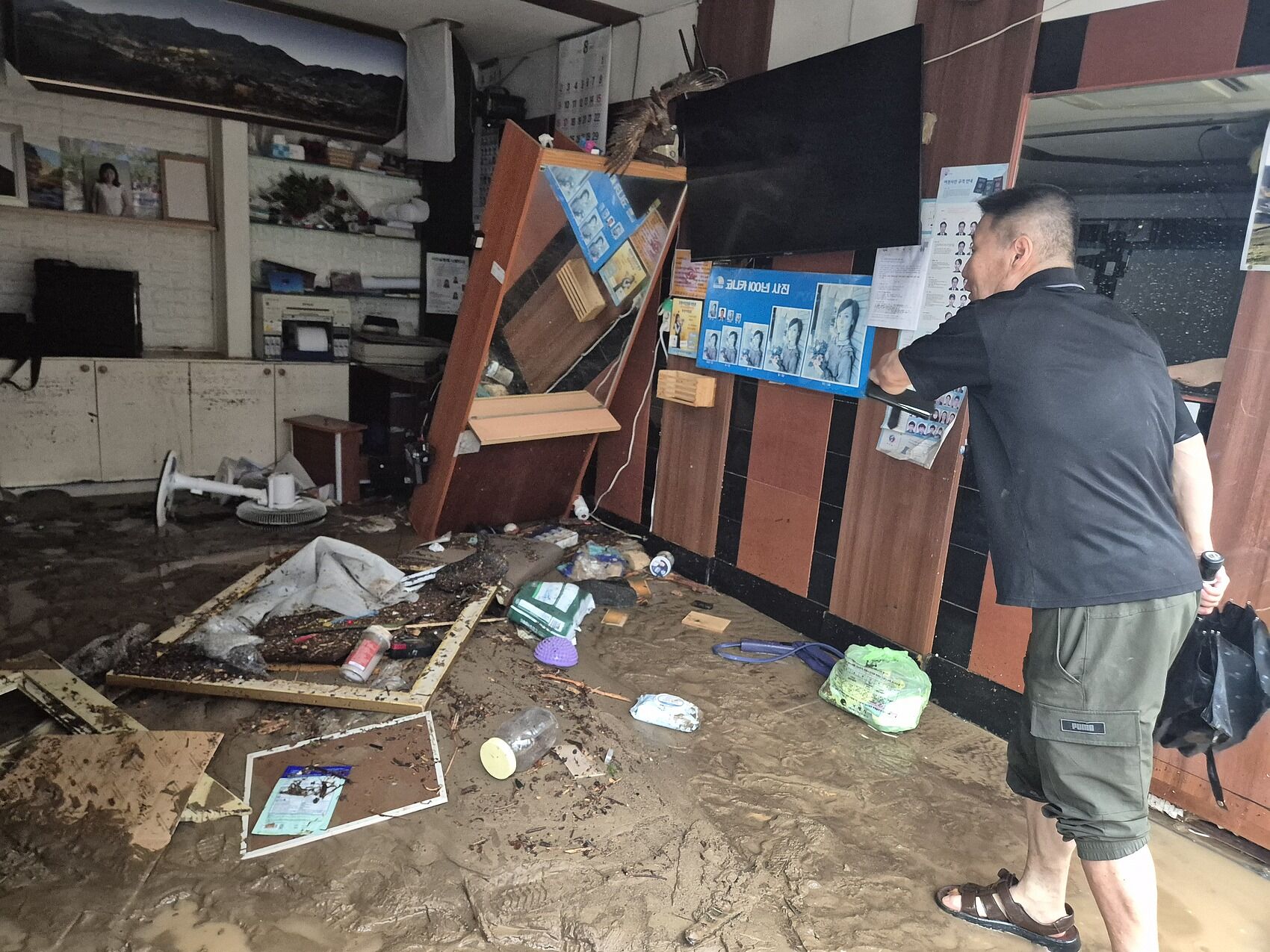 ▲▼南韓慶尚南道巨濟市玉浦洞因極限暴雨，道路瀝青遭掀起、店鋪玻璃破碎，當地照相館遭洪水泥流灌入。（圖／VCG）
