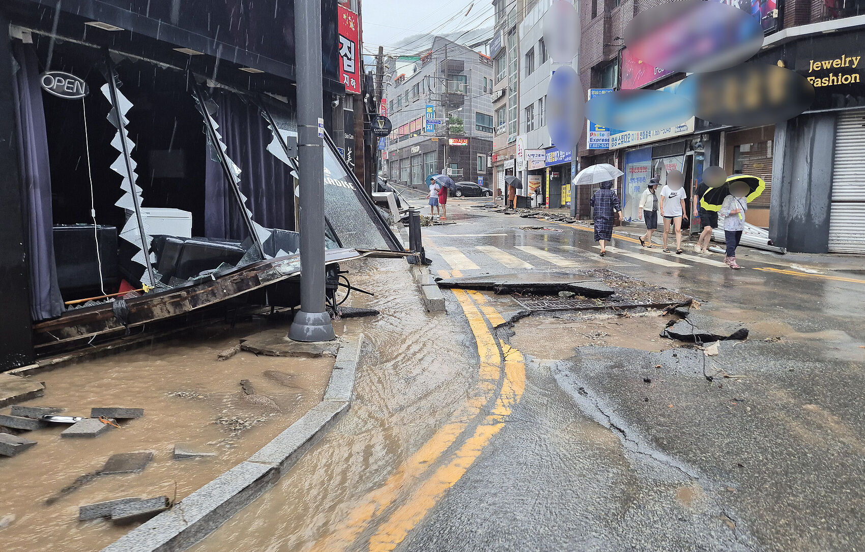 ▲▼南韓慶尚南道巨濟市玉浦洞因極限暴雨，道路瀝青遭掀起、店鋪玻璃破碎，當地照相館遭洪水泥流灌入。（圖／VCG）