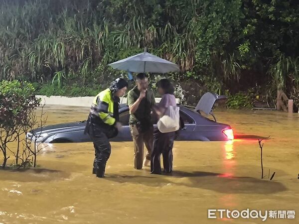 ▲新北石門台二線29K嚴重淹水導致道路雙向中斷，一輛賓士車一度受困水中，所幸車上兩人已順利脫困。（圖／記者郭世賢翻攝）
