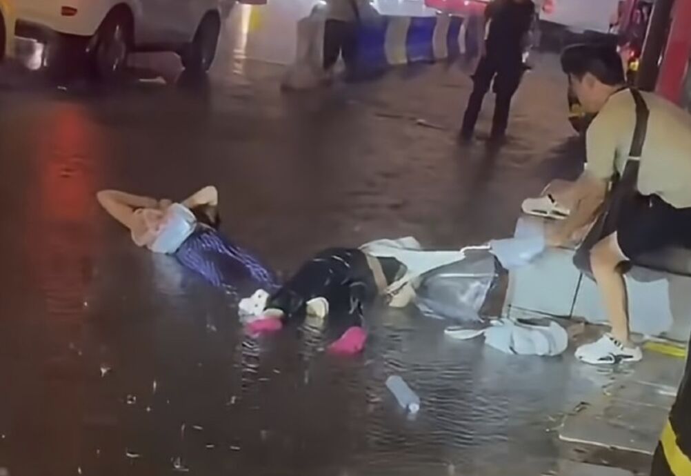 陸遊客遭電擊倒積水地不起 路人怕觸電用3把雨傘勾人救命