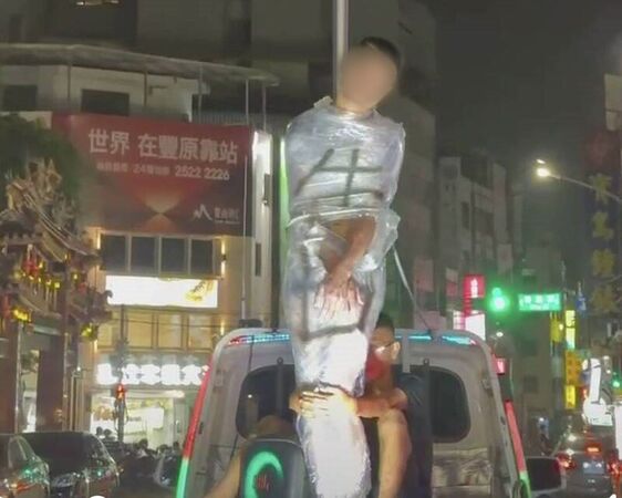 台中市豐原區昨日驚見一名男子疑似在慶祝生日，遭親友惡整綁在貨車後車斗，嚇得民眾報警處理。（翻攝照片）