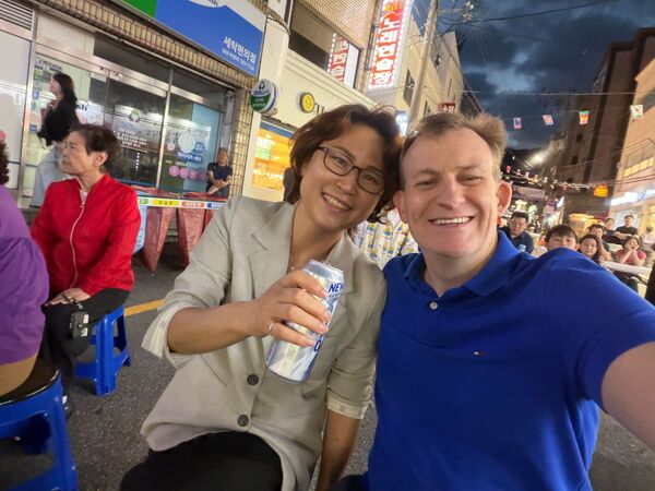凱利（右）和妻子金正雅（左）參加街頭慶典。（翻攝X@Robert_E_Kelly）