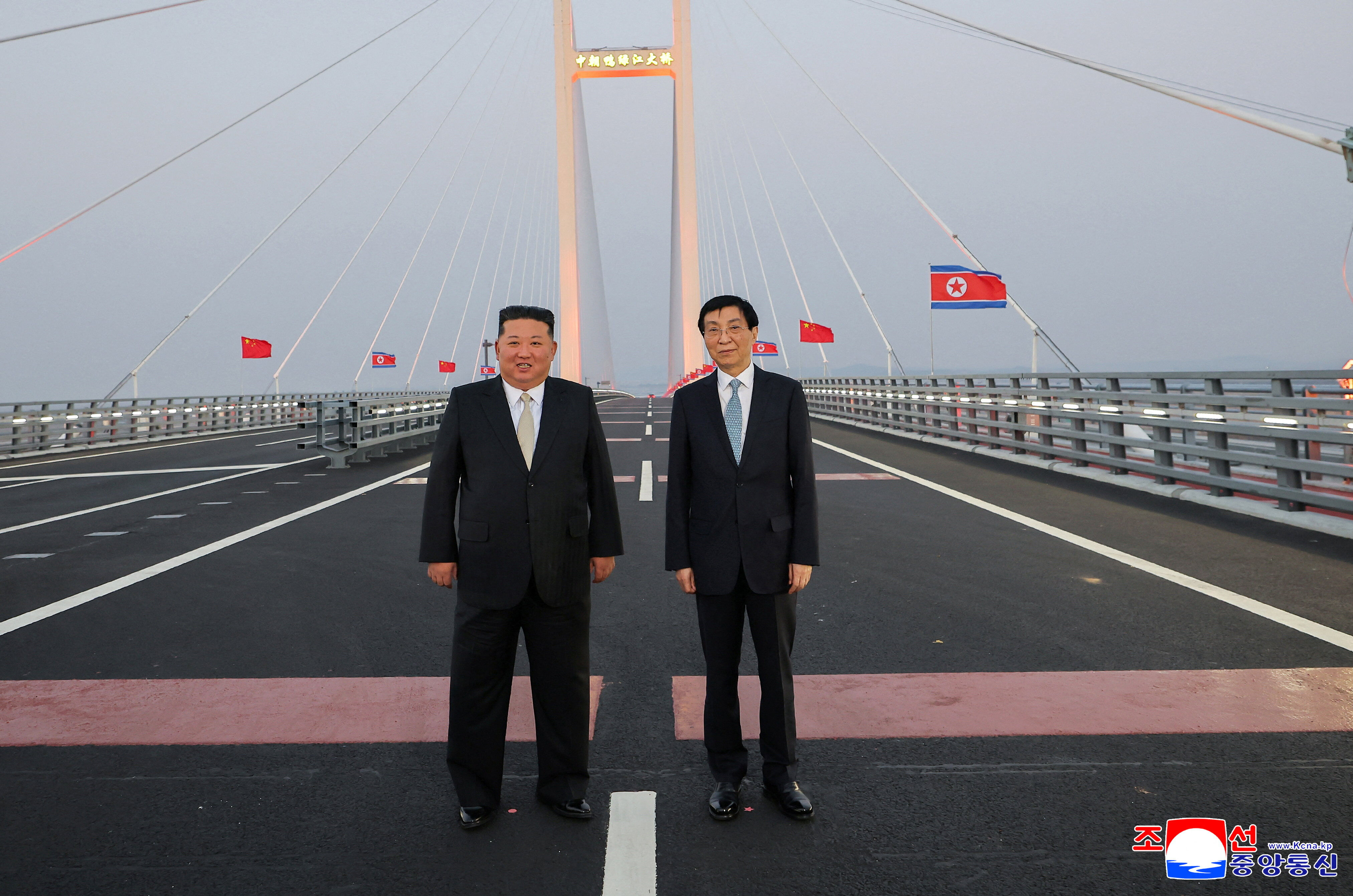 ▲▼金正恩返程經由通車不久的新鴨綠江大橋,並向人群揮手致意。(圖/路透)